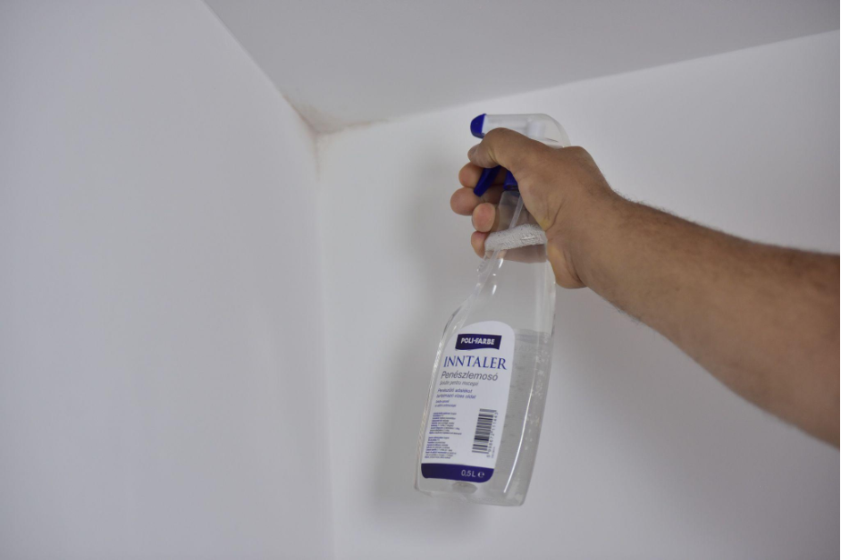 Poli-Farbe Inntaller penészírtó üveg penészes falhoz közelítve, rá irányítva